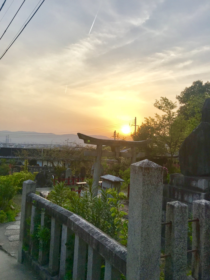 Un sanctuaire traditionnel au coucher du soleil avec une vue sur la ville.