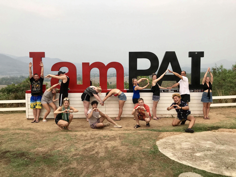 Tourists posing in front of a large sign that reads 'I am Pai'.