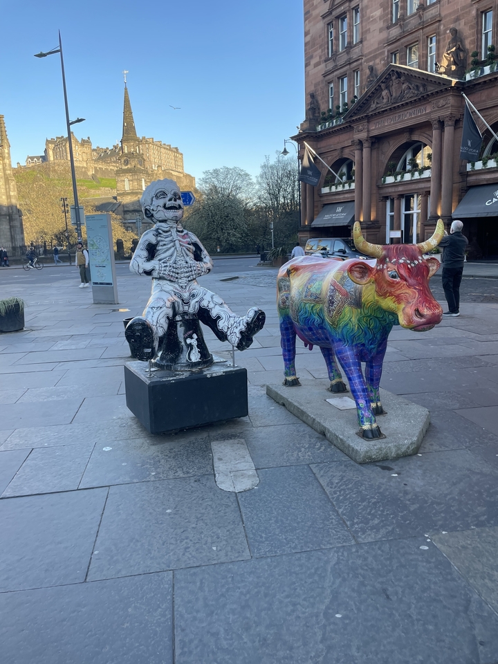 Deux statues colorées d'une personne et d'une vache.