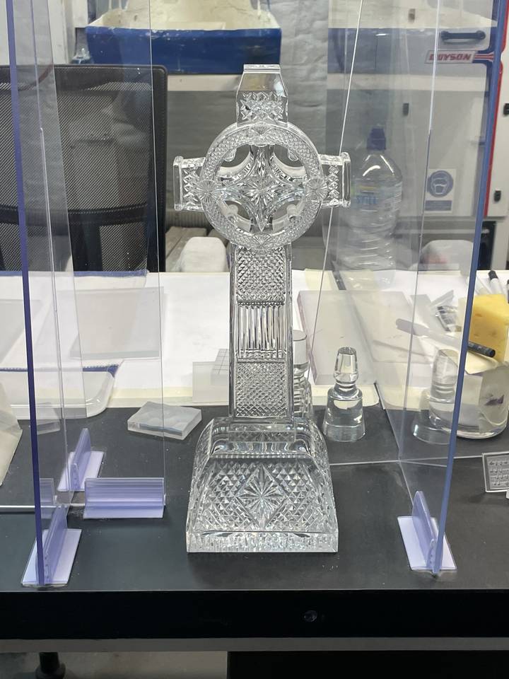 Croix en cristal sur un présentoir, design complexe.