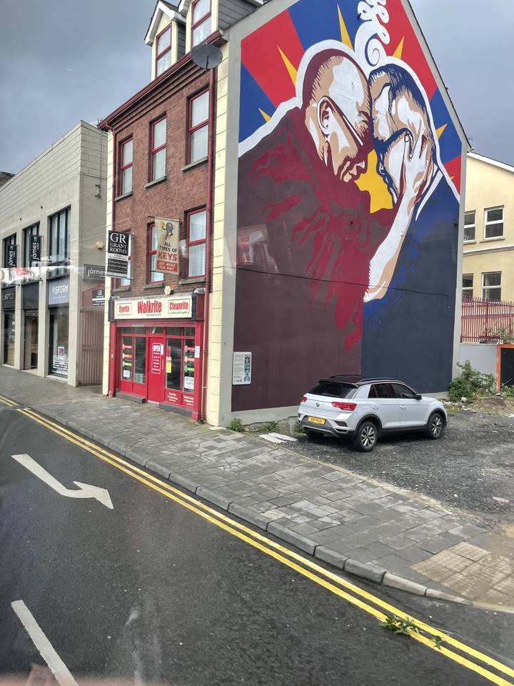 Fresque colorée d'un homme avec une imagerie iconique, vue de rue.