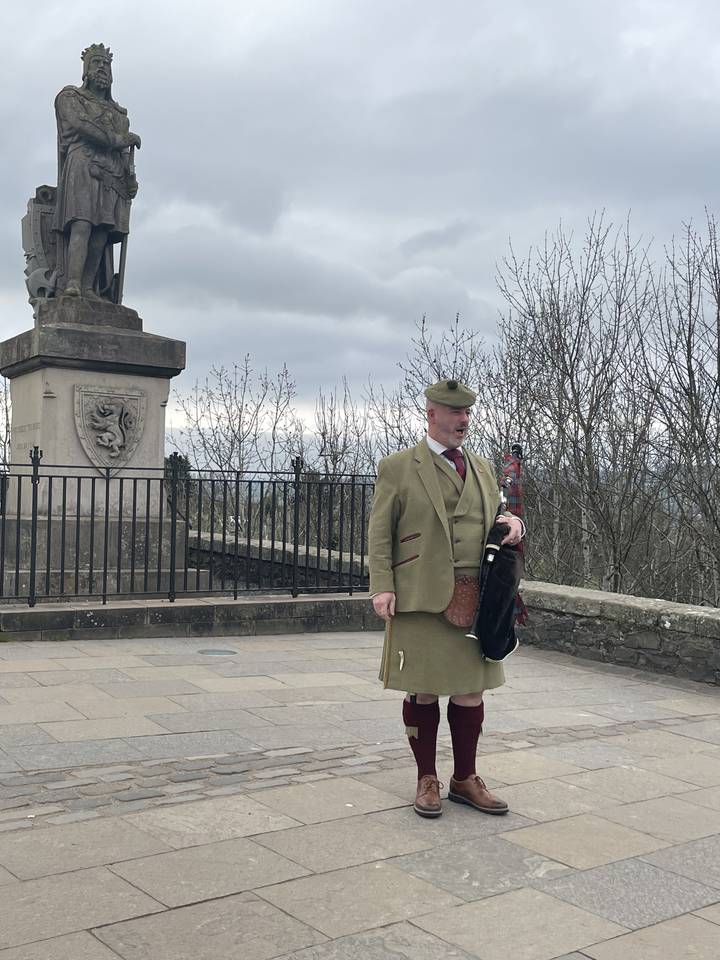 Personne en vêtements traditionnels se tient sur une place.