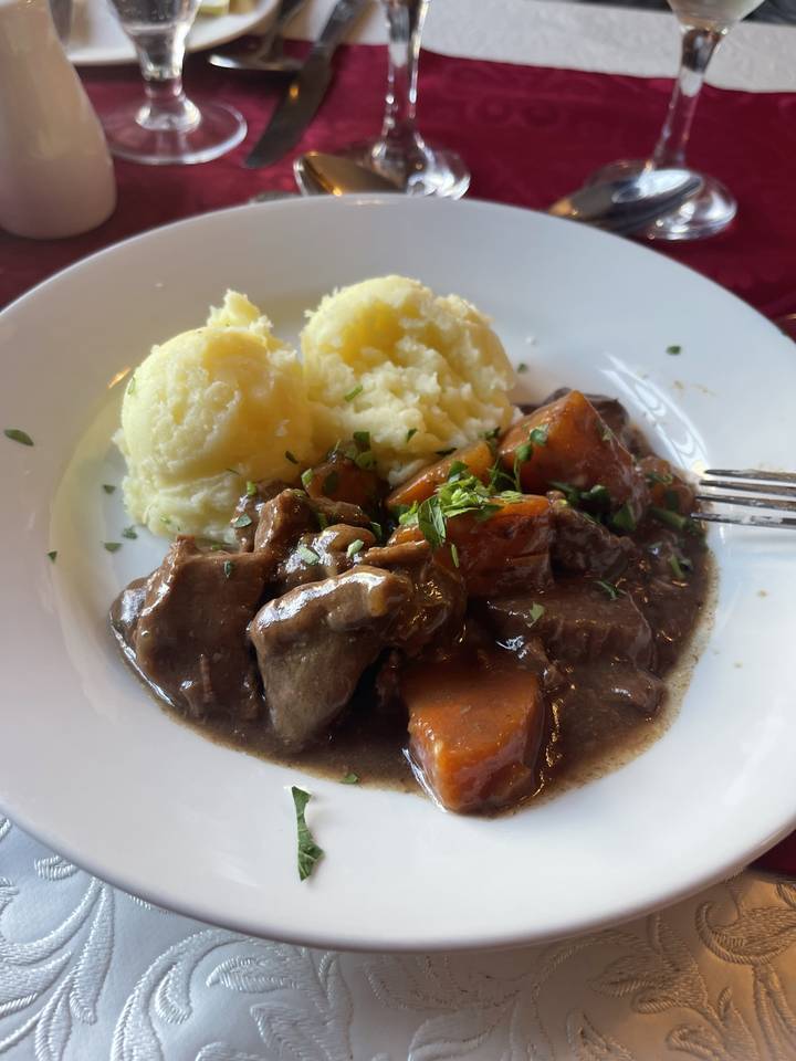 Plate of mashed potatoes with beef stew.