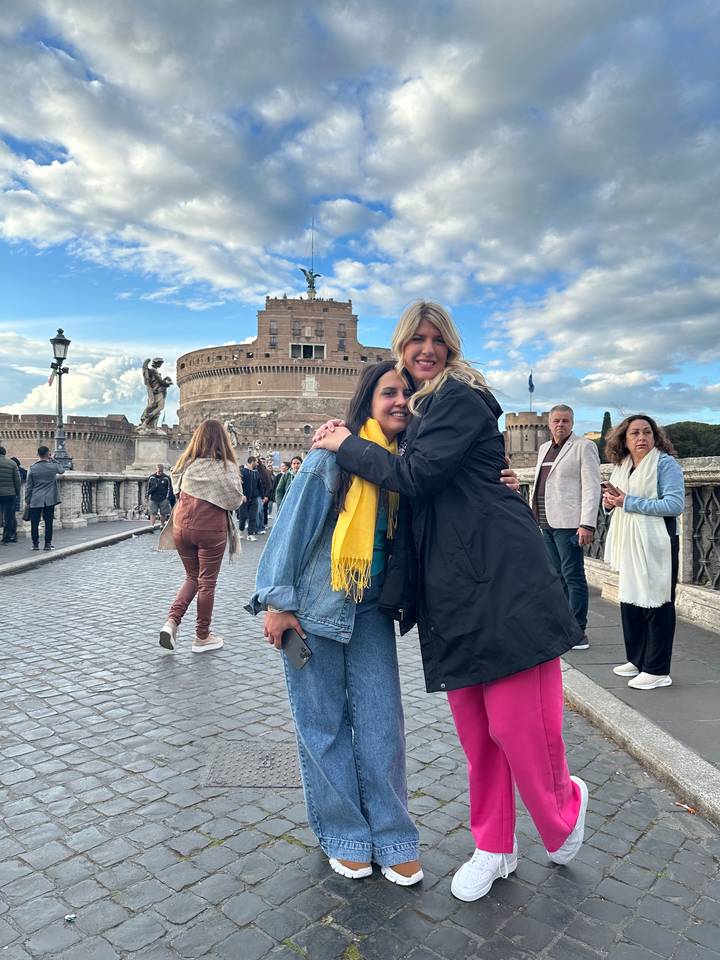 Deux personnes qui s'embrassent devant un bâtiment historique.
