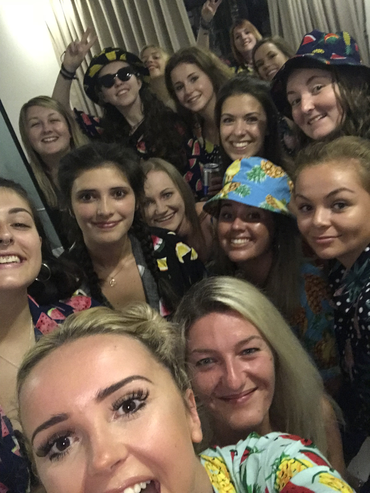 Selfie de groupe de personnes souriantes à l'intérieur.