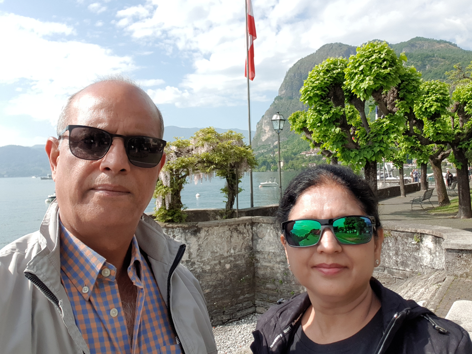 Couple posant au bord d'un lac avec des arbres.