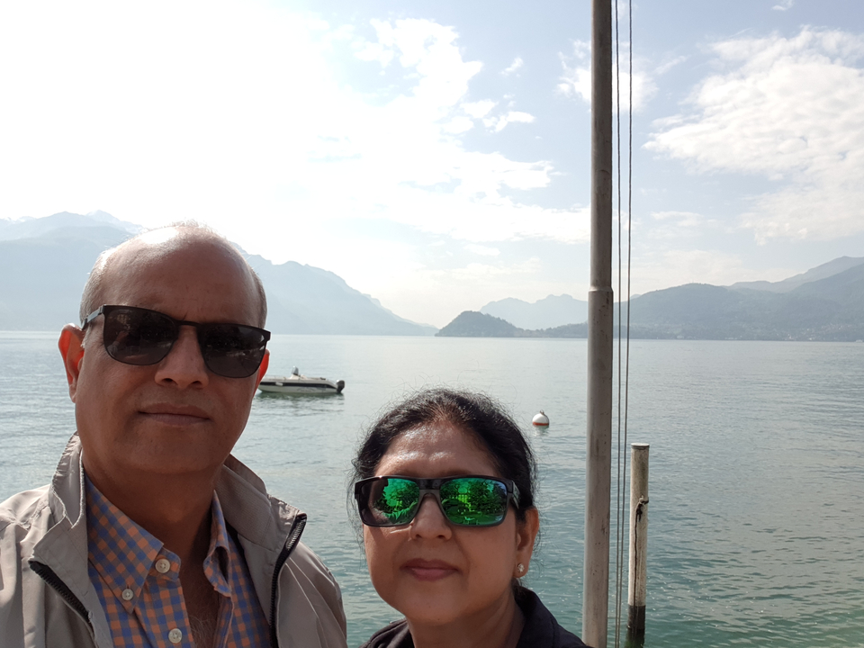 Couple posant au bord d'un lac avec des montagnes.