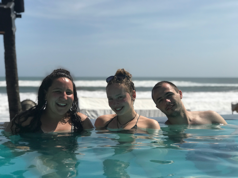 People submerged in a swimming pool by the sea.