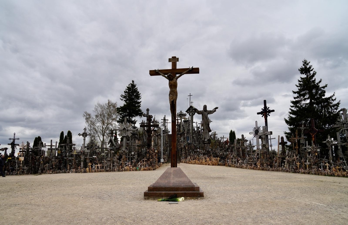 Colline des croix avec de nombreuses croix et symboles religieux sur fond de ciel nuageux.