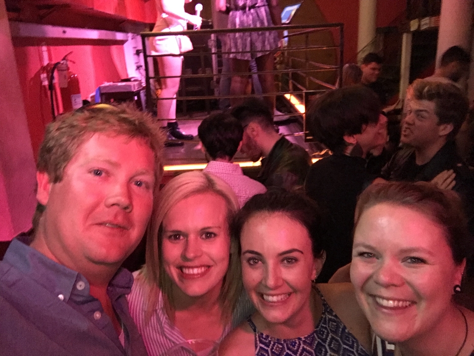 Groupe de personnes profitant d'une boîte de nuit animée avec une scène en arrière-plan.