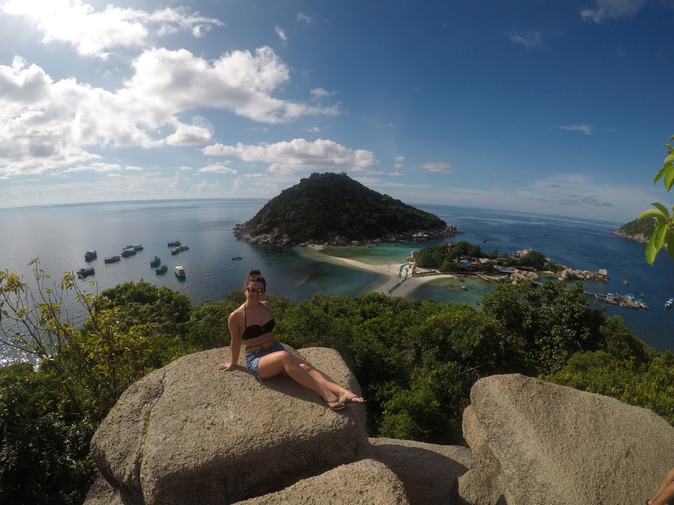 Woman posing on a rock with a stunning island view.