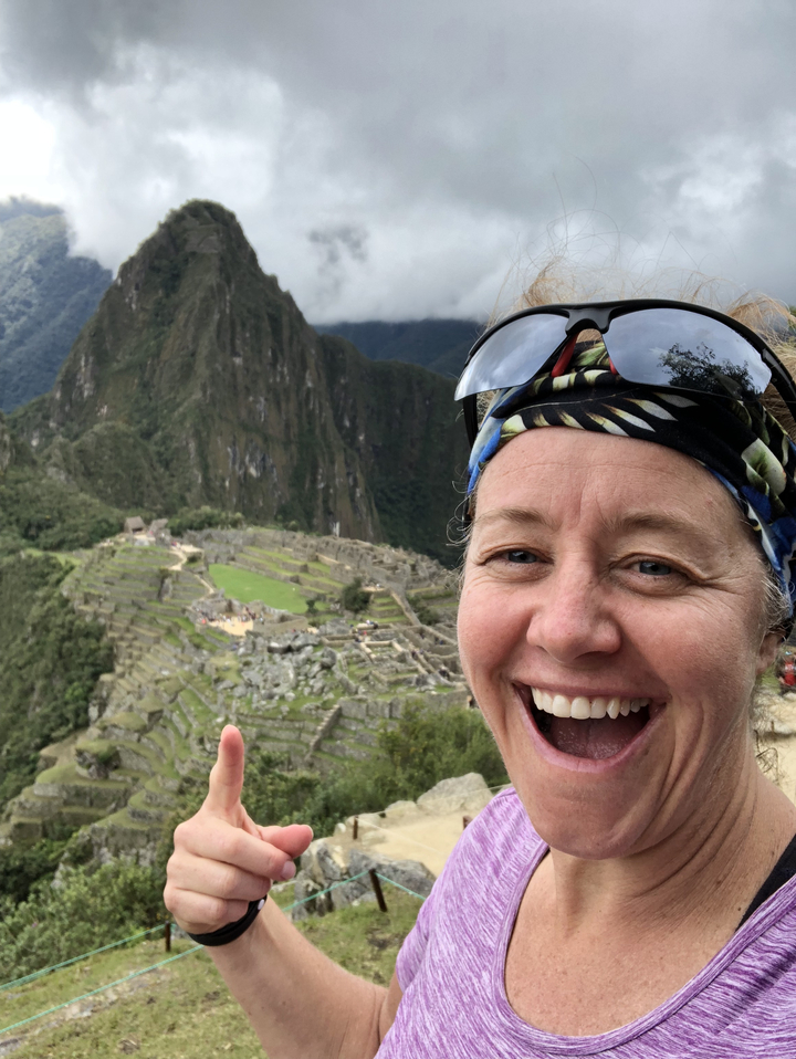 Personne souriante avec le Machu Picchu en arrière-plan.