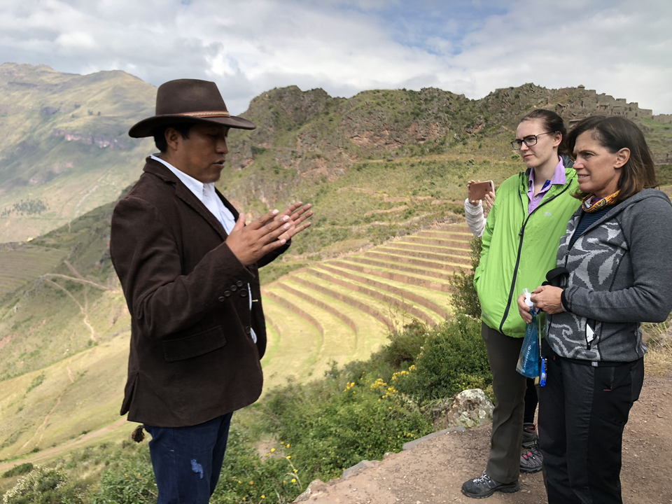 Guide touristique expliquant aux visiteurs le paysage en terrasses à l'arrière-plan.