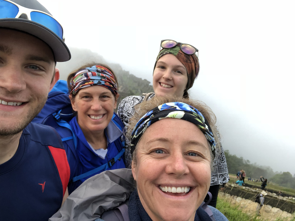 Selfie de groupe sur fond de nuages et de montagnes.