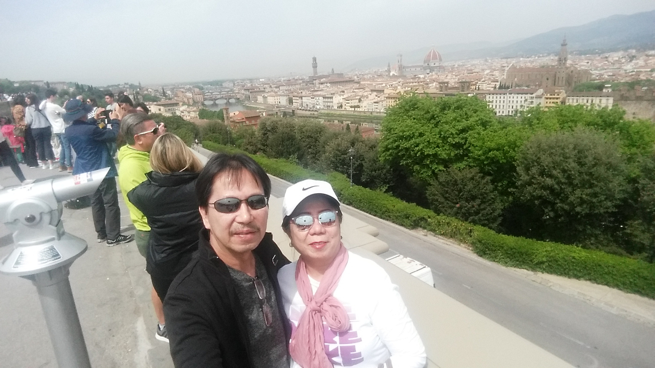 Couple posant avec une vue panoramique de Florence.