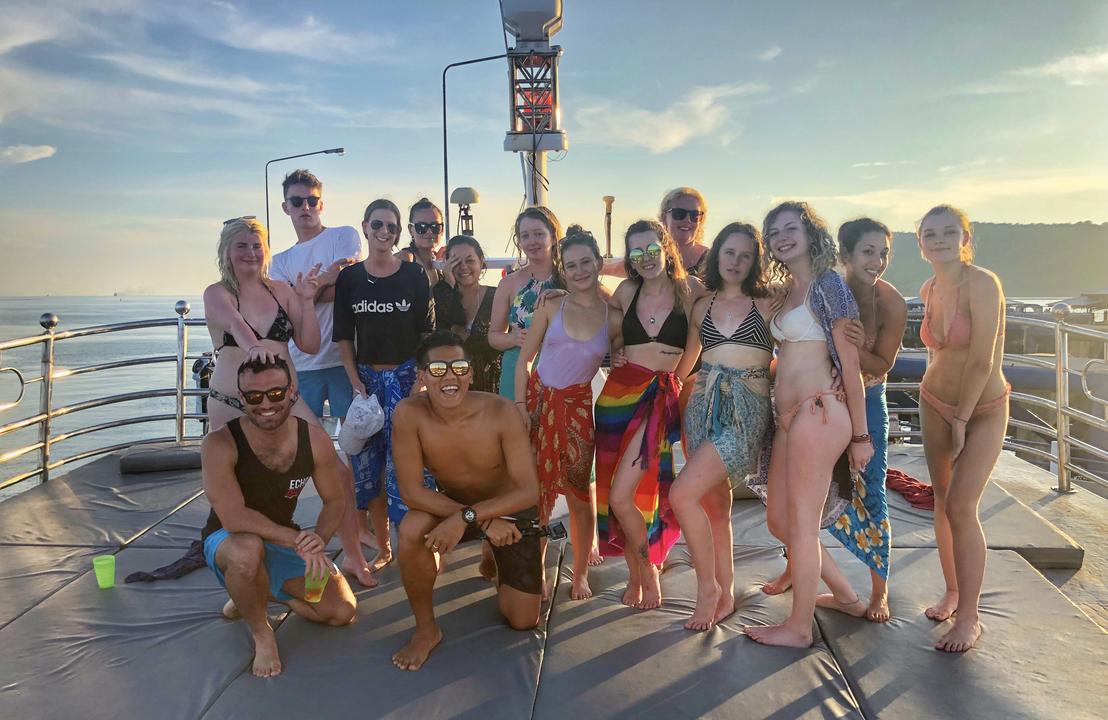 Fête de groupe sur un bateau avec un arrière-plan pittoresque.