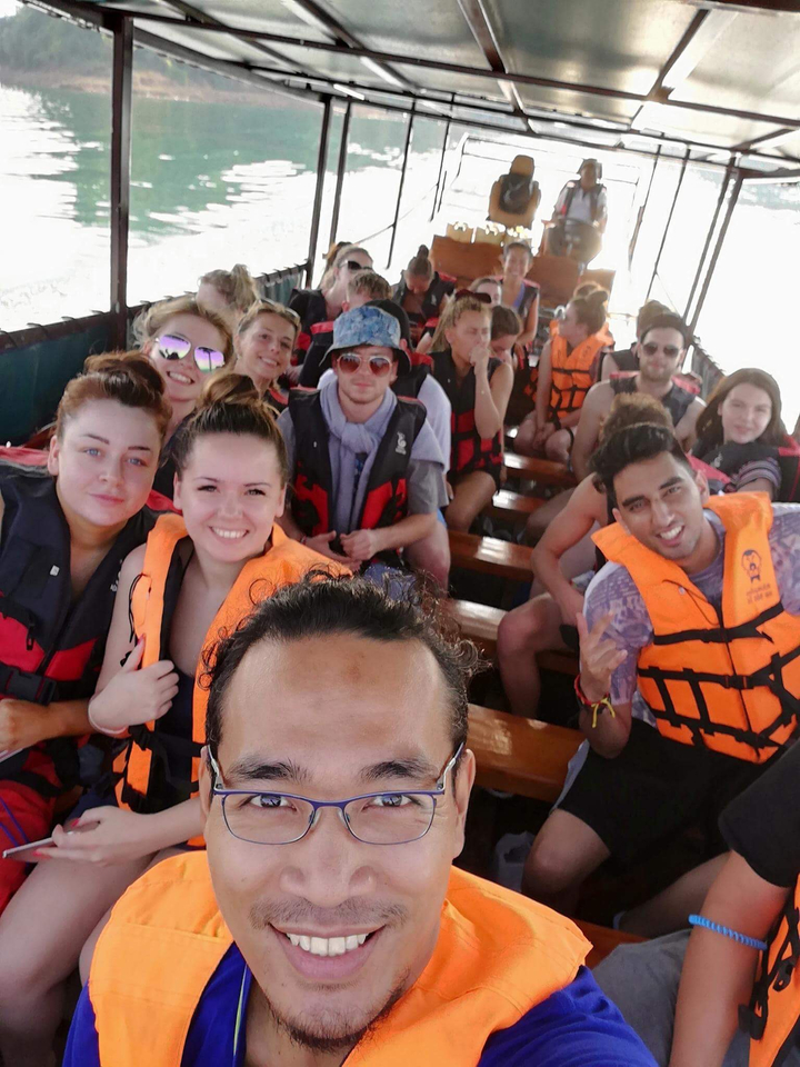 Groupe sur un bateau portant des gilets de sauvetage et profitant de la promenade.