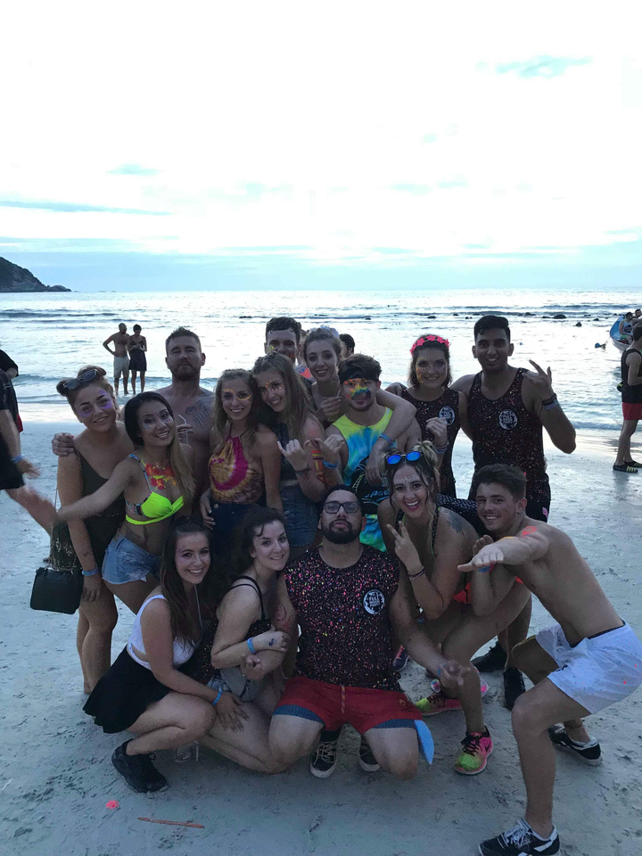 Groupe en tenues colorées profitant de l'ambiance de la plage au crépuscule.