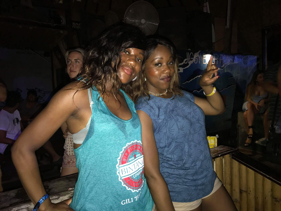 Two women in a dark room posing for a photo.