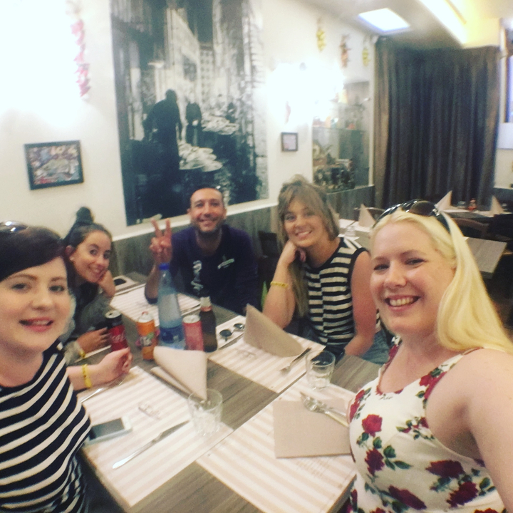 Un groupe d'amis, à l'intérieur, souriant à une table.