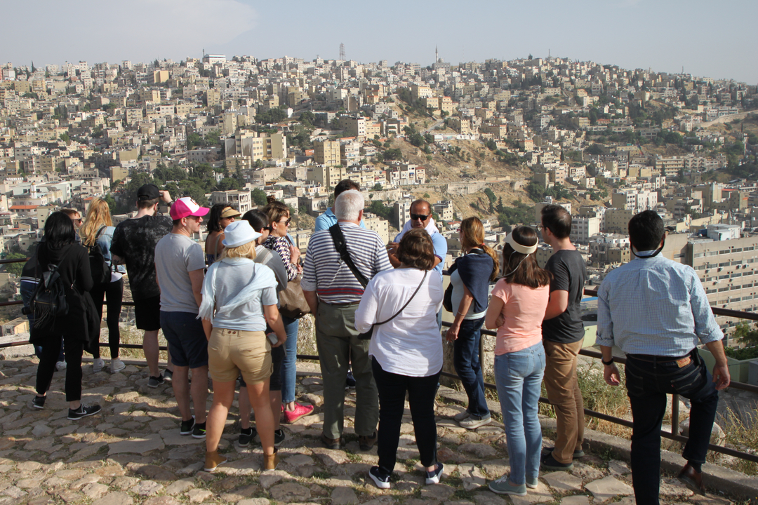 Groupe de personnes observant une ville depuis un point d'observation.