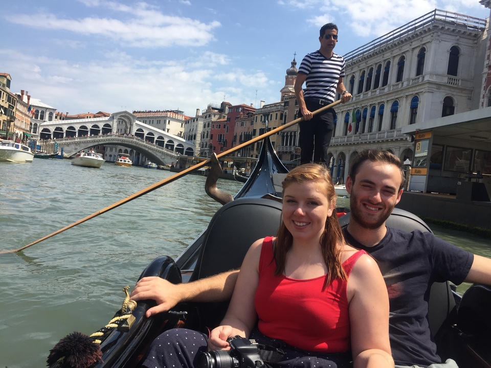 Couple en gondole avec le pont du Rialto à Venise en vue.