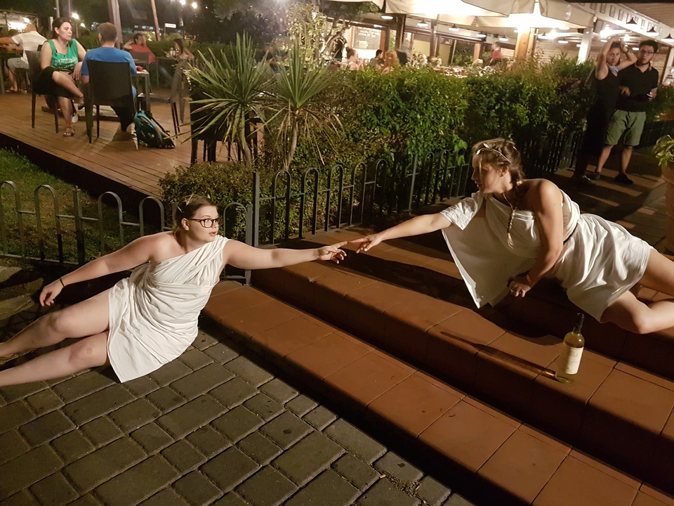 Deux personnes prenant une pose théâtrale sur des escaliers extérieurs.