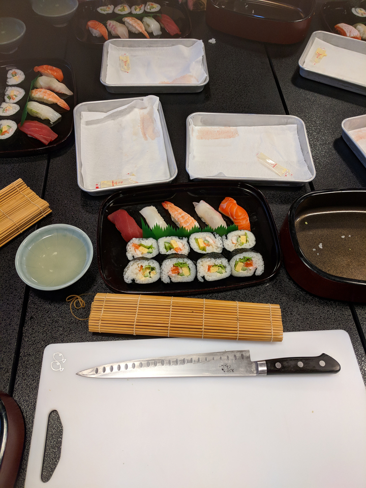 Un plateau de sushis avec différents types de sushis et de sashimis présentés sur une table.