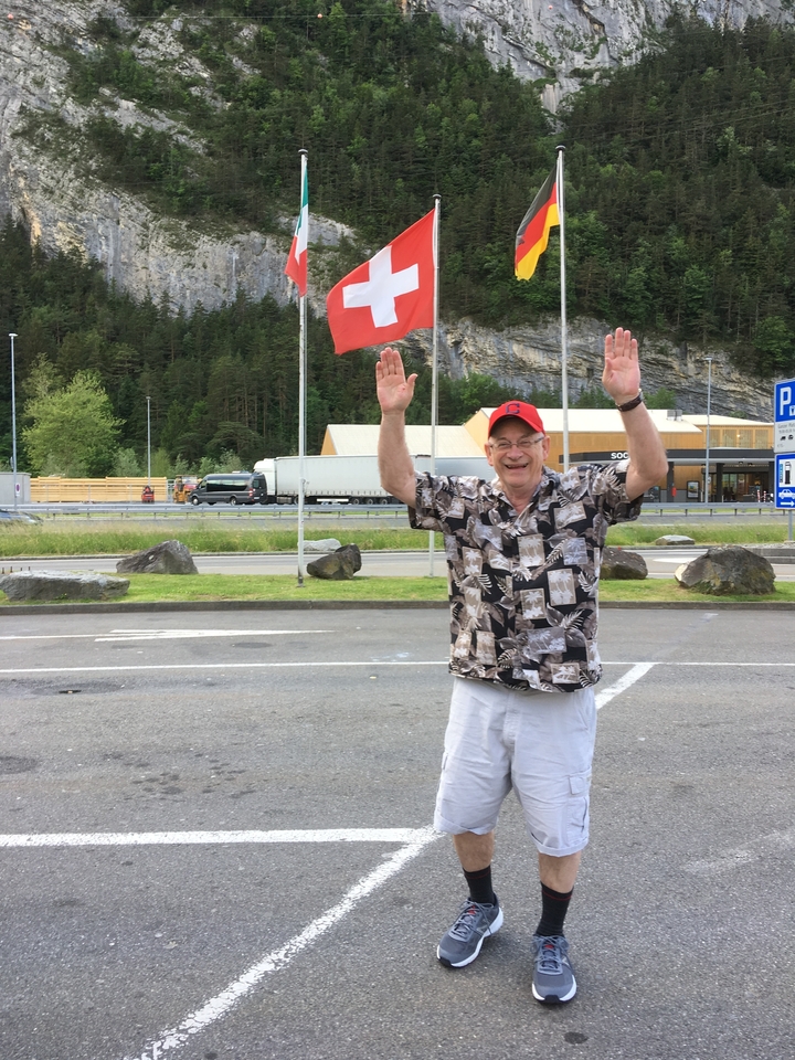 Homme levant les bras joyeusement dans un parking.