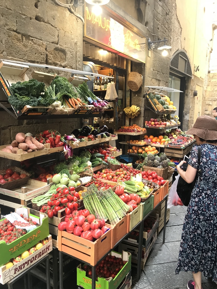 Marché en plein air avec une grande variété de fruits et légumes frais et un service de consultation pour les clients.