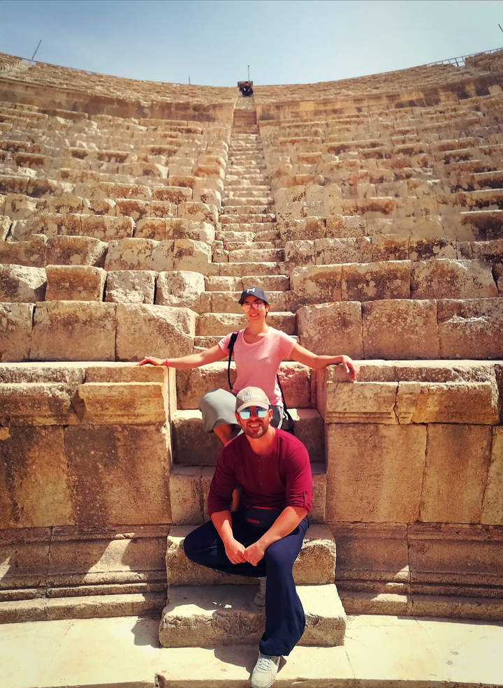 Couple assis sur d'anciennes marches en pierre en plein air.
