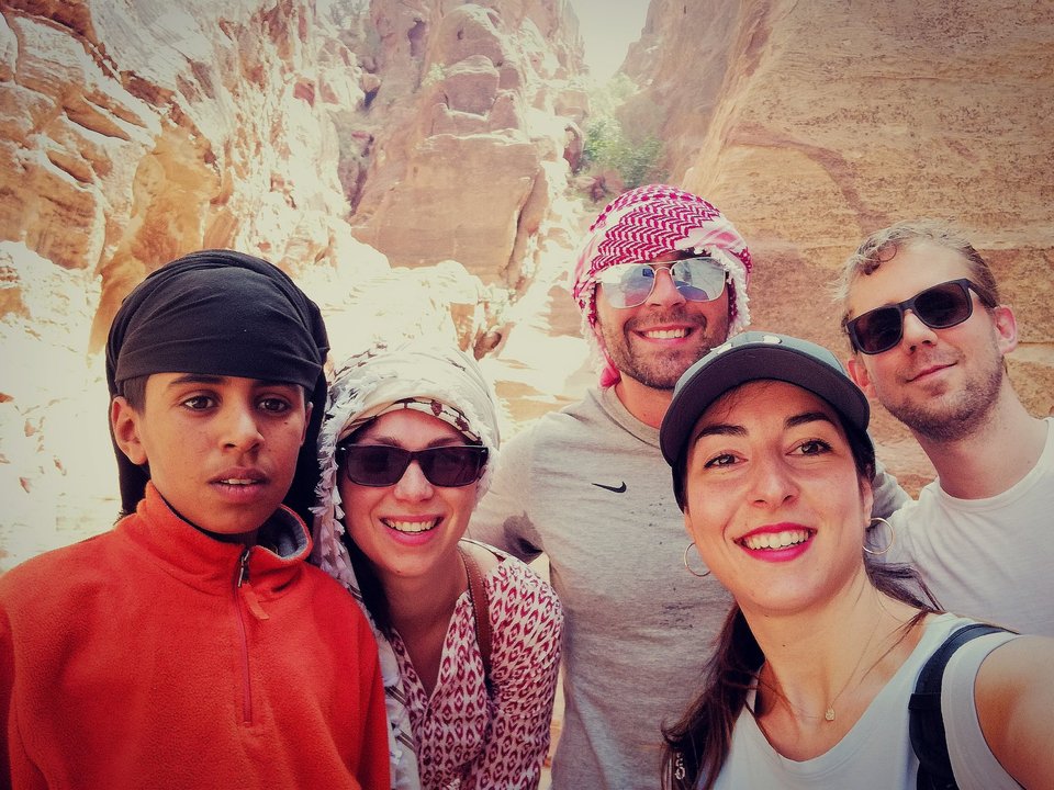 Group of five people posing in a canyon-like setting.