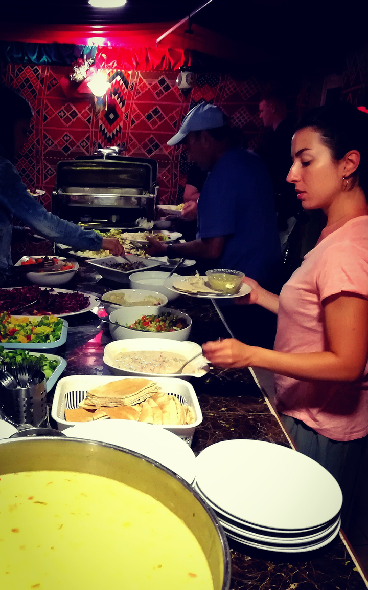 Groupe choisissant de la nourriture dans un buffet composé de différents plats.