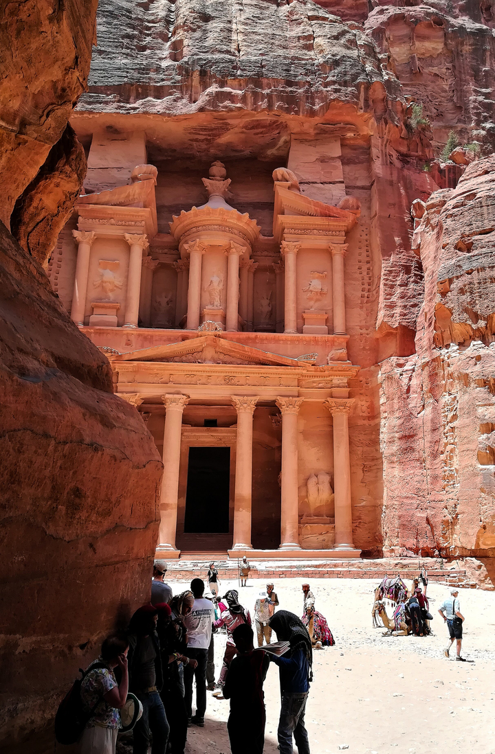 Spectaculaire façade taillée dans le roc d'une ancienne cité sous un fort ensoleillement.
