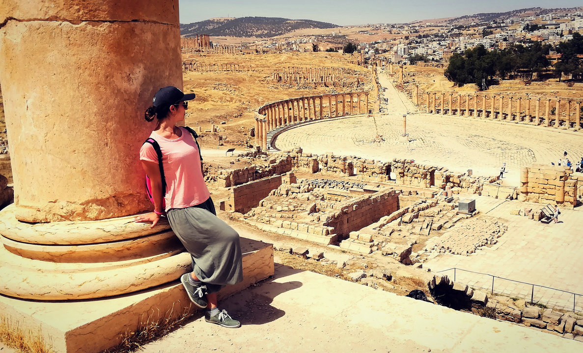 Personne posant avec une vue panoramique de ruines anciennes.