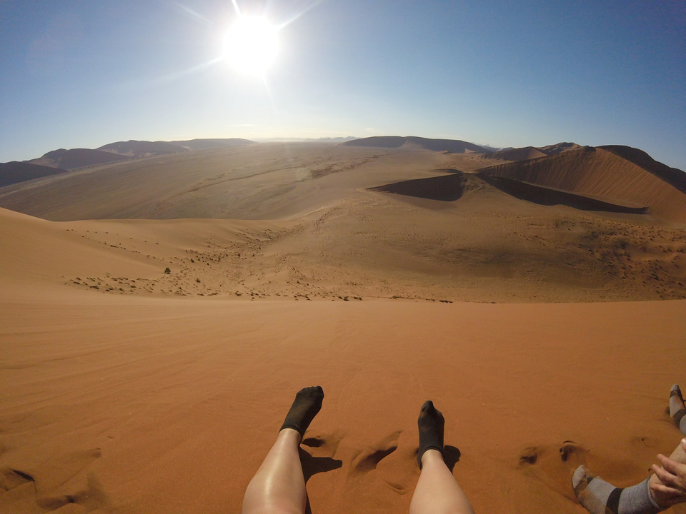 Les pieds dans les dunes de sable d'un vaste paysage désertique.