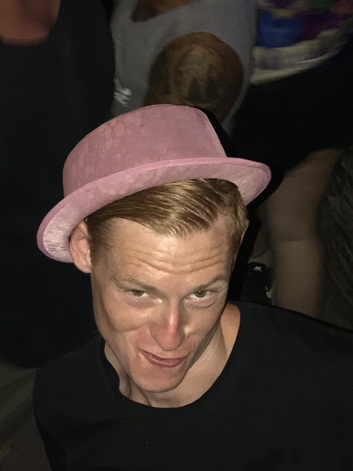 Close-up of a man wearing a pink hat.