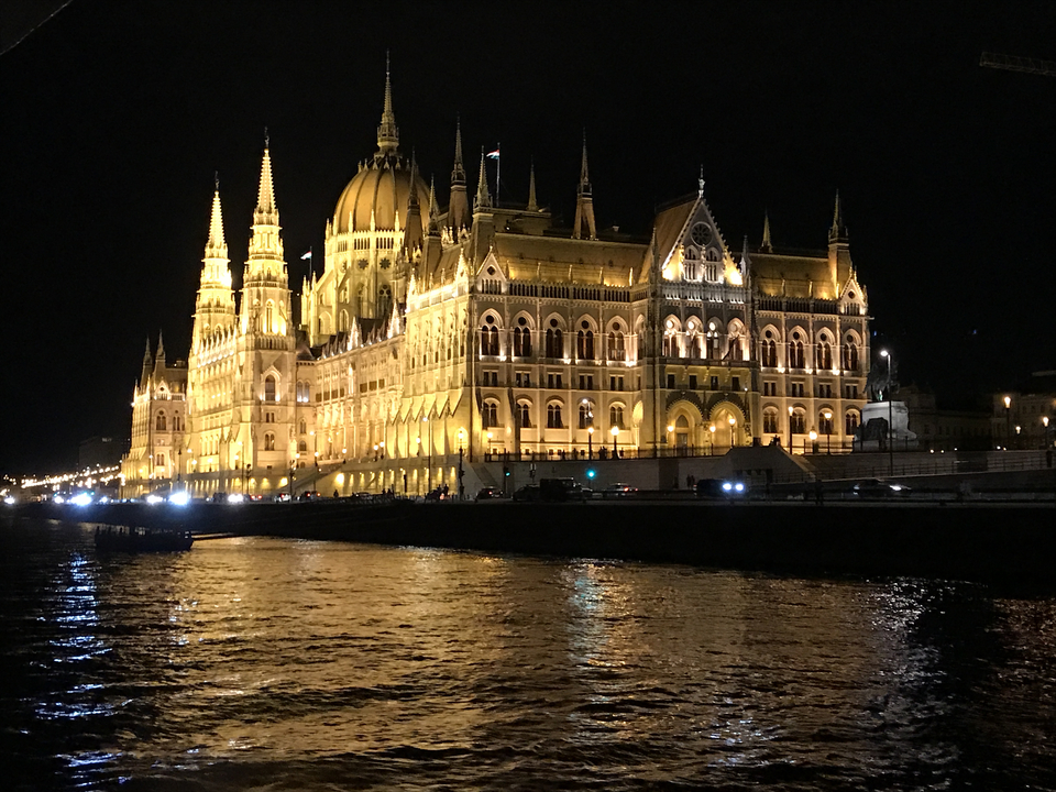 Ein wunderschön beleuchtetes Gebäude bei Nacht, das sich im Fluss spiegelt.