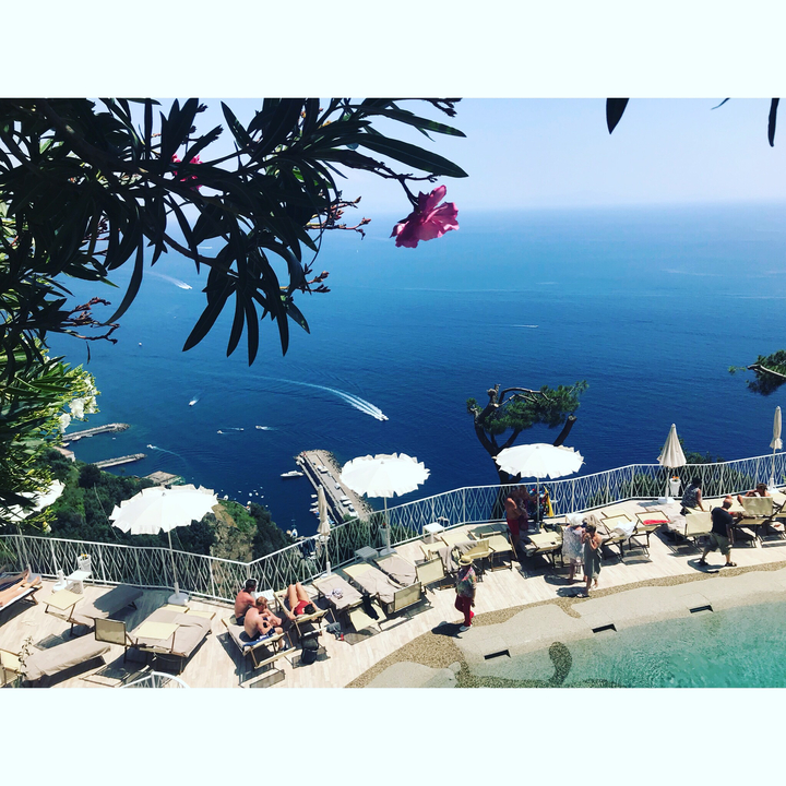 Une terrasse avec des tables donnant sur la mer et le littoral.