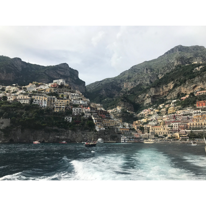 Ville à flanc de colline avec des bâtiments colorés le long de la côte rocheuse.