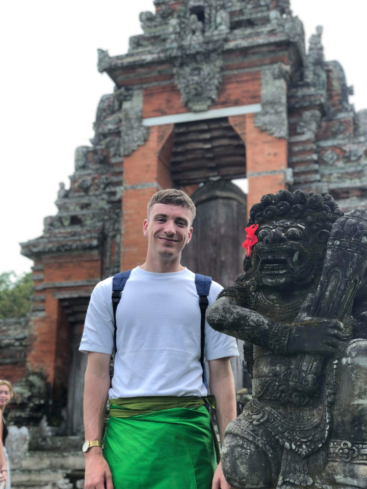 Man posing with a traditional statue.