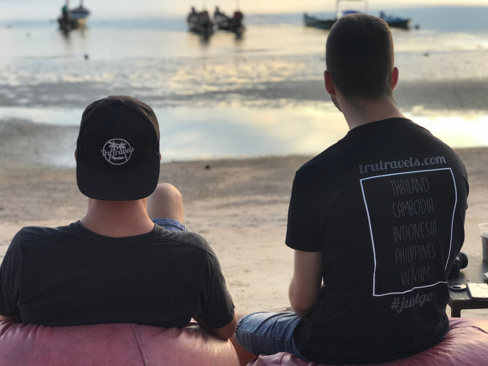 Two people sitting side by side at dusk.