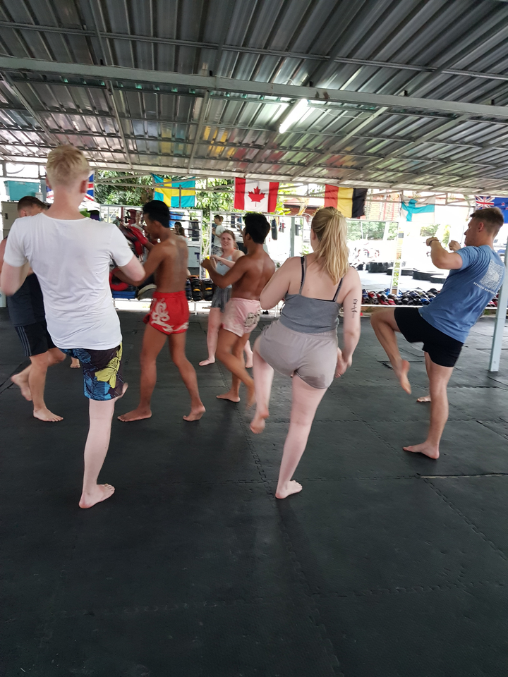 Groupe de personnes pratiquant les arts martiaux dans un gymnase.