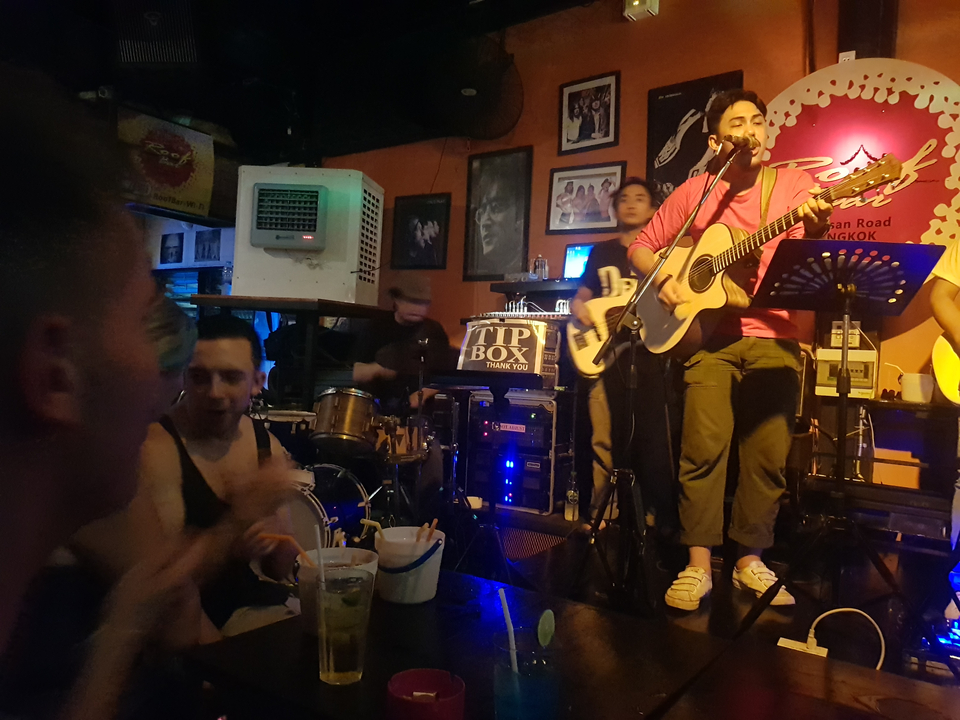 Un groupe de musique se produit dans un pub faiblement éclairé.