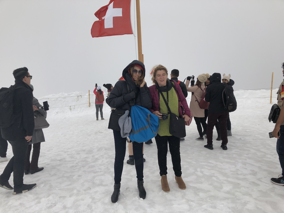 People bundled up in winter clothes standing in a snowy landscape.