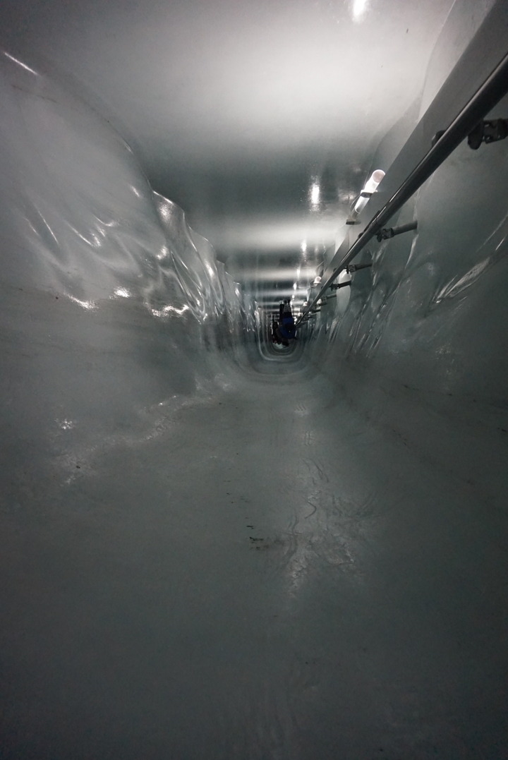 View of an icy tunnel with reflective walls.