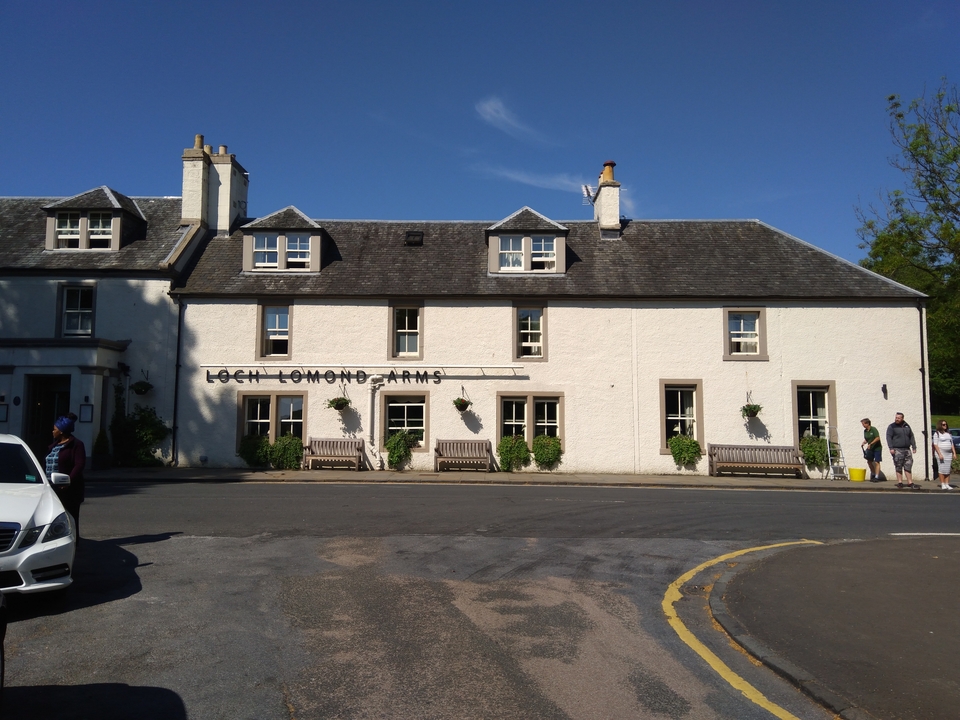 Pub Loch Lomond Arms avec des bancs devant.