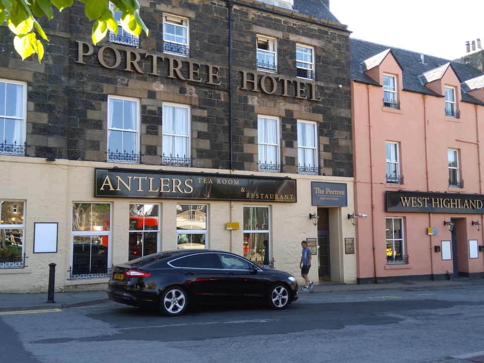 Façade de l'hôtel Portree avec une voiture noire garée devant.