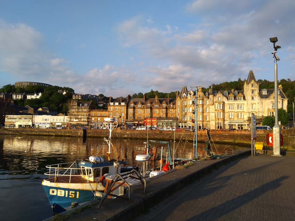 Paysage urbain d'un port avec des bâtiments historiques et des bateaux de pêche.