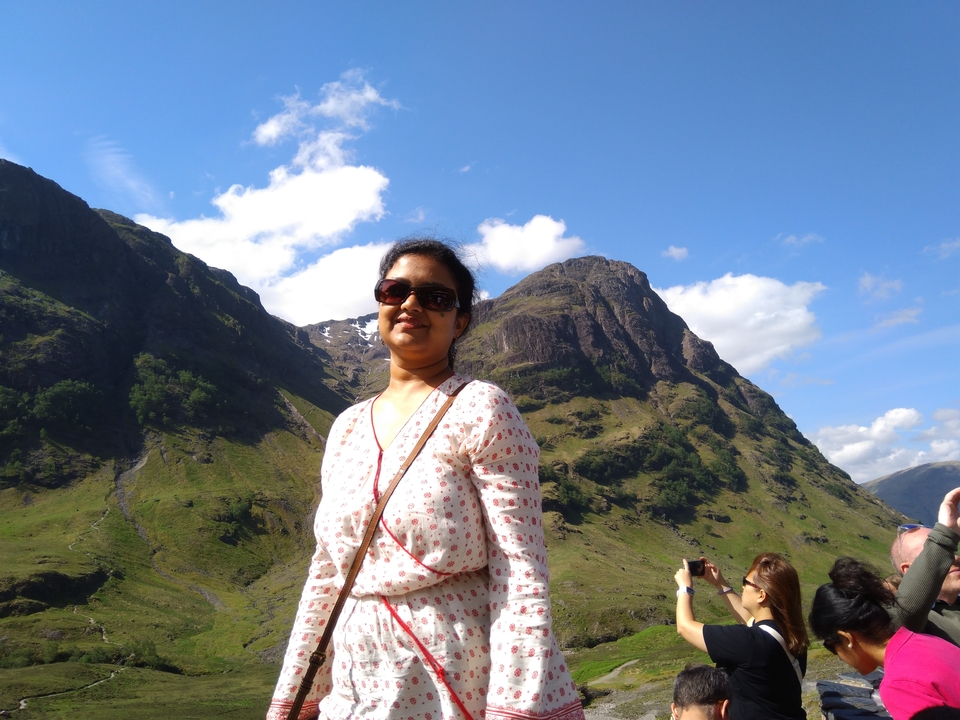 Personne posant devant un paysage de montagne.